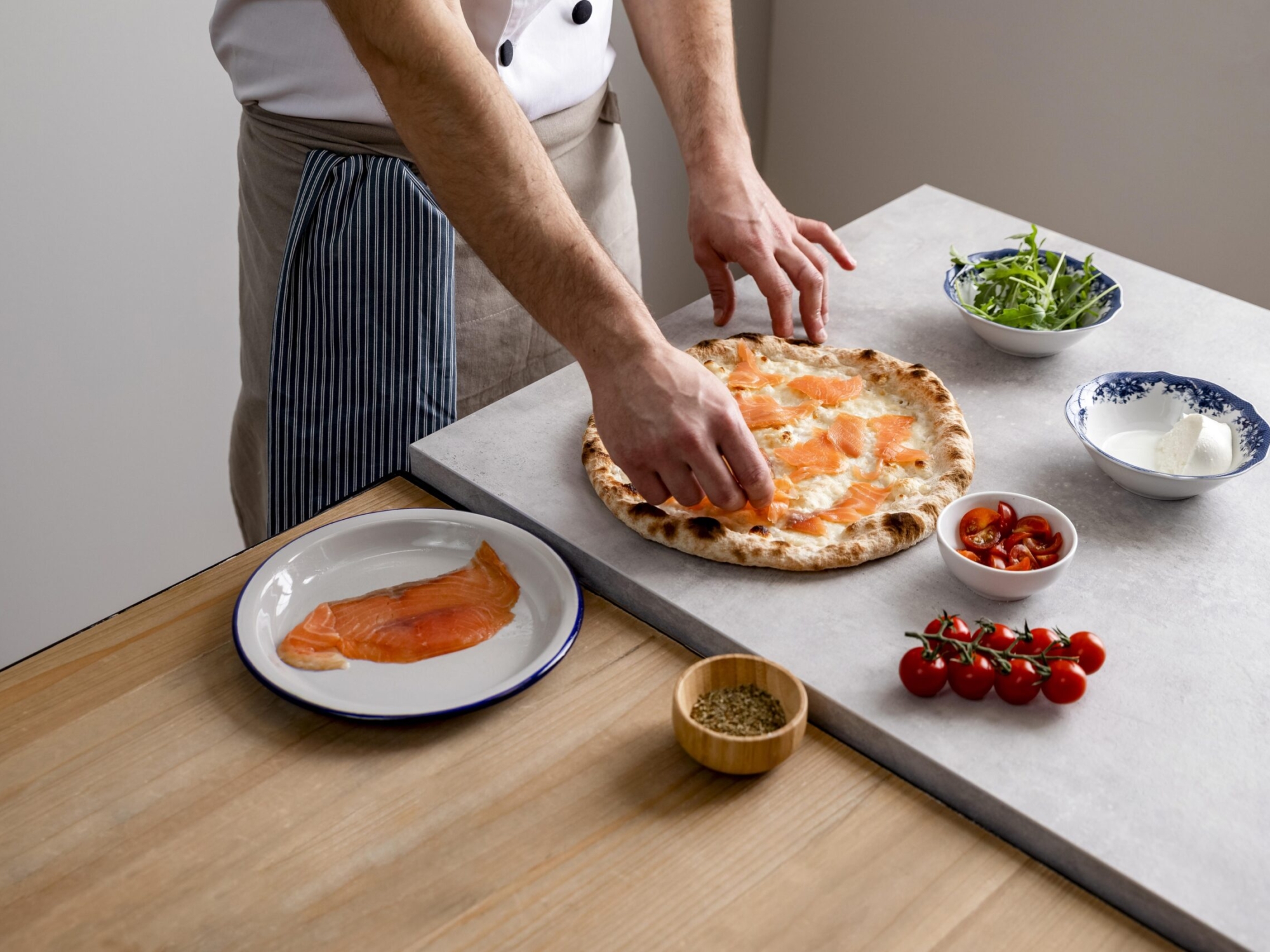 hombre-alto-angulo-poniendo-rodajas-salmon-ahumado-sobre-masa-pizza-al-horno