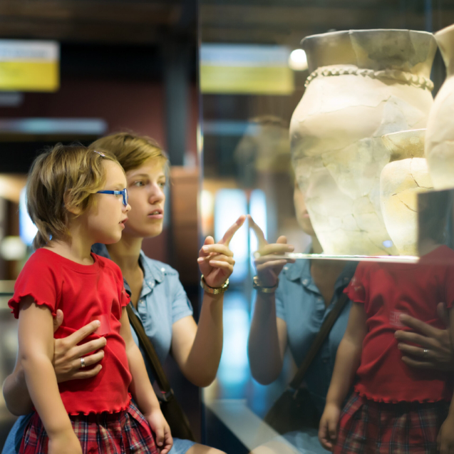 mother and child looking ancient amphores in  museum