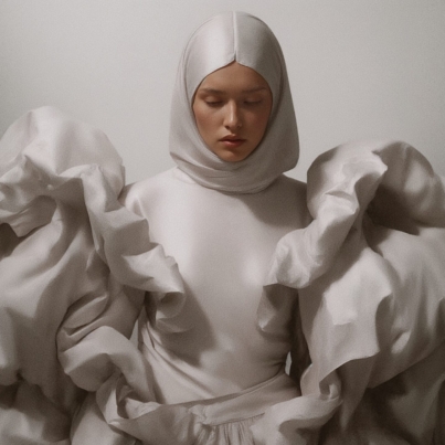 Mujer vestida con un diseño escultórico blanco, símbolo de la fusión entre arte, moda e inteligencia artificial, creado por VEIA VISUALS para representar la belleza emocional del marketing con valores.